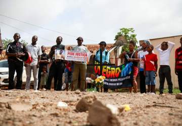 Com cruz, velas e flores, grupo protesta contra violência após morte de haitiano