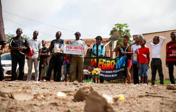 Com cruz, velas e flores, grupo protesta contra violência após morte de haitiano